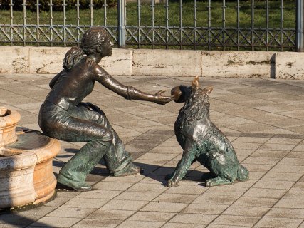 Statue einer Frau mit spielendem Hund